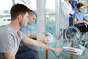 Different people sitting in waiting room hospital