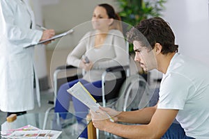 Different people sitting in waiting room hospital