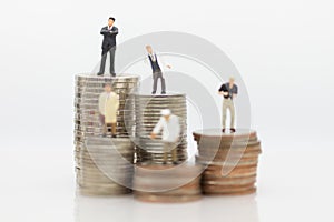 Different people standing on stack coins, using as salaries are different from many occupations concept
