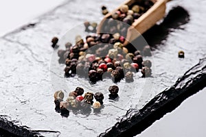 Different pepper spices on a black slate. Ingredients for cooking. Healthy eating concept. Various spices on dark background. Heal