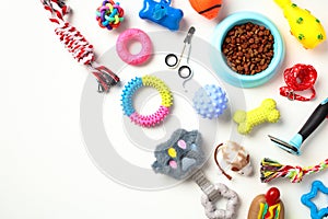 Different pet supplies and toys, bowl of dry food on white background. Pet care, training, grooming concept