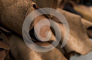 Different pieces of leather in a rolls. The pieces of the colored leathers. Rolls of natural brown red leather. Raw