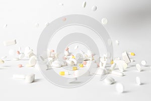Different pills falling on table