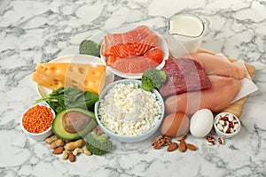 Different products rich in protein on marble table