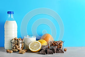 Different products on stone table against light blue background. Food allergy concept