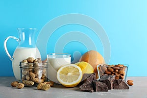 Different products on stone table against light blue background. Food allergy concept