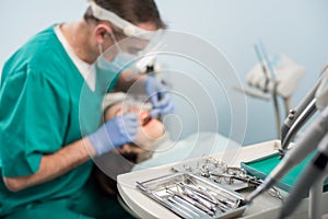 Different professional dental devices, on the blurred background dentist is treating patient in dental office