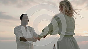 Different races couple smiles and dances happily at seaside