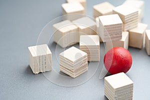 Different red ball in the group of wooden cubes