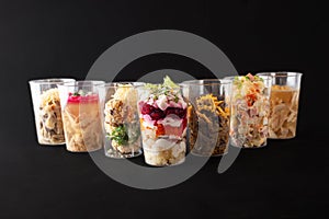 Different salads and snacks in cups, studio photo. Catering, food delivery