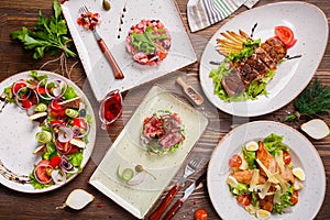 Different salads on wooden table, top view.
