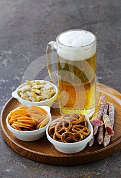 Different salted snacks and a glass of fresh beer