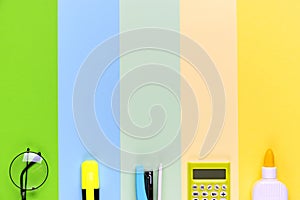 Different school tools on colorful paper copy space background