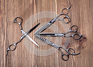 Different scissors on brown wooden table