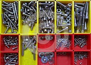 Different screws in separated red and yellow plastic boxes
