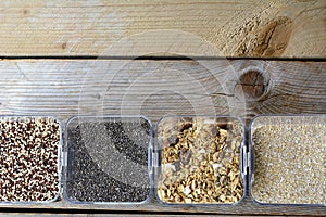 Different seeds in the bowls are standing on the wooden background. Healthy seeds for people