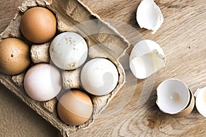 Different shades of farm fresh eggs on wood