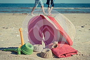Different shapes made of sand, children toys for playing and accessories for relax on beach. Summer time