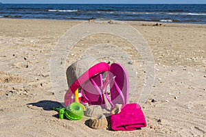 Different shapes made of sand, children toys for playing and accessories for relax on beach. Summer time