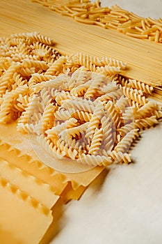 Different shapes and types of raw pasta: Curly Macaroni ,Vermicelli, Spaghetti, Spaghettini,Fusilli, Girandole, Maccheroni,