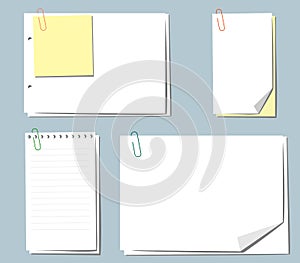Different sheets of note papers and paper clips on blue background