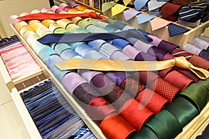 Different silk neckties on shelves