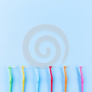 Different size interdental brush angles on blue background, copy space, square format