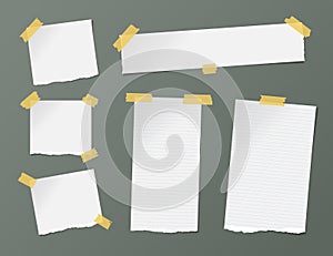 Different size white ruled note, notebook, copybook sheets, strips stuck with yellow sticky tape on dark background