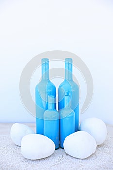 Different sizes four blue bottles as a vase idea for your home in Mediterranean style.