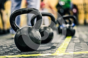 Different sizes of kettlebells weights lying on gym floor. photo