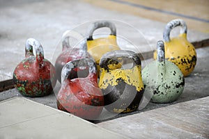 Different sizes of kettlebells weights lying on gym floor. Equip