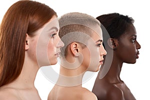 Different skin tones. Side view of three beautiful multicultural young women.Two caucasian and african half naked women