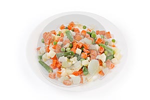 Different sliced frozen vegetables on white dish on white background
