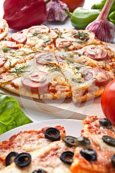 Different sliced pizzas with ingredients