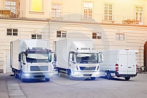 Different small and medium courier service  trucks and van at building courtyard. City delivery cargo shipping company vehilcles