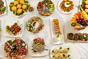 Different snacks for eating on holiday in white plates on white background. Kitchen, menu, food concept . delicious dish