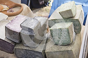 Different sorts of cheese wheels at a market