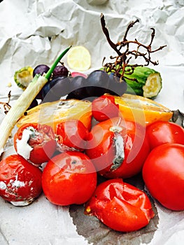 Different sorts of rotten fruits and vegetables on gray paper