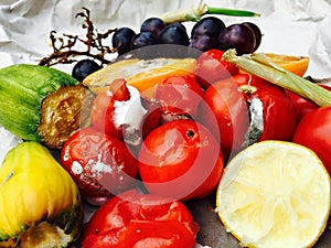 Different sorts of rotten fruits and vegetables on gray paper