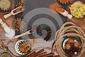 Different spices in bakeware with wooden scoops on the slate slone
