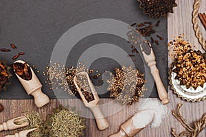 Different spices in bakeware with wooden scoops on the slate slone background