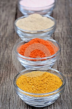 Different spices in a bowls on old table