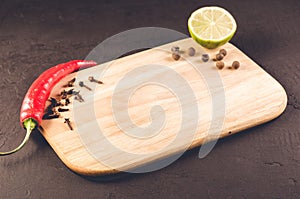 Different spices and empty cutting board/ Different spices and empty cutting board on a dark background. Copy space