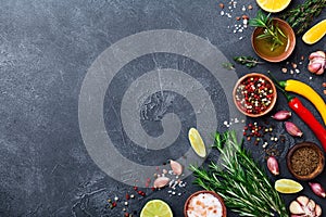 Different spices and herbs on black stone table top view. Ingredients for cooking. Food background.