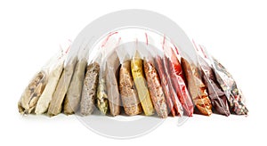 Different spices in plastic bags on white background