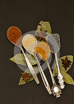 Different spices in silver spoons