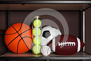 Different sport balls on shelf near brown wall