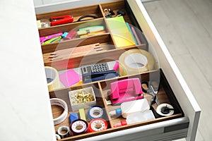 Different stationery in open desk drawer