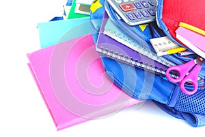 Different stationery and school supplies lying in a school backpack on a white isolated background