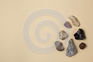 Different stones, precious and rocks on a beige background. Gemological concept. Study of minerals and bowels of the earth.
